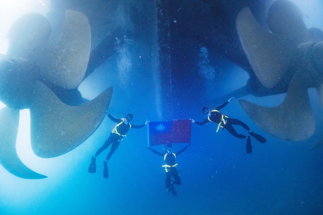 水下作業大隊官兵在水下與國旗合影。（軍聞社記者陳彥樺攝）