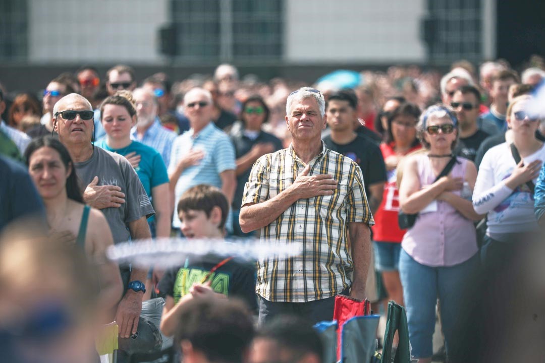 民眾將手放置胸前齊唱國歌，現場氣氛令人動容。