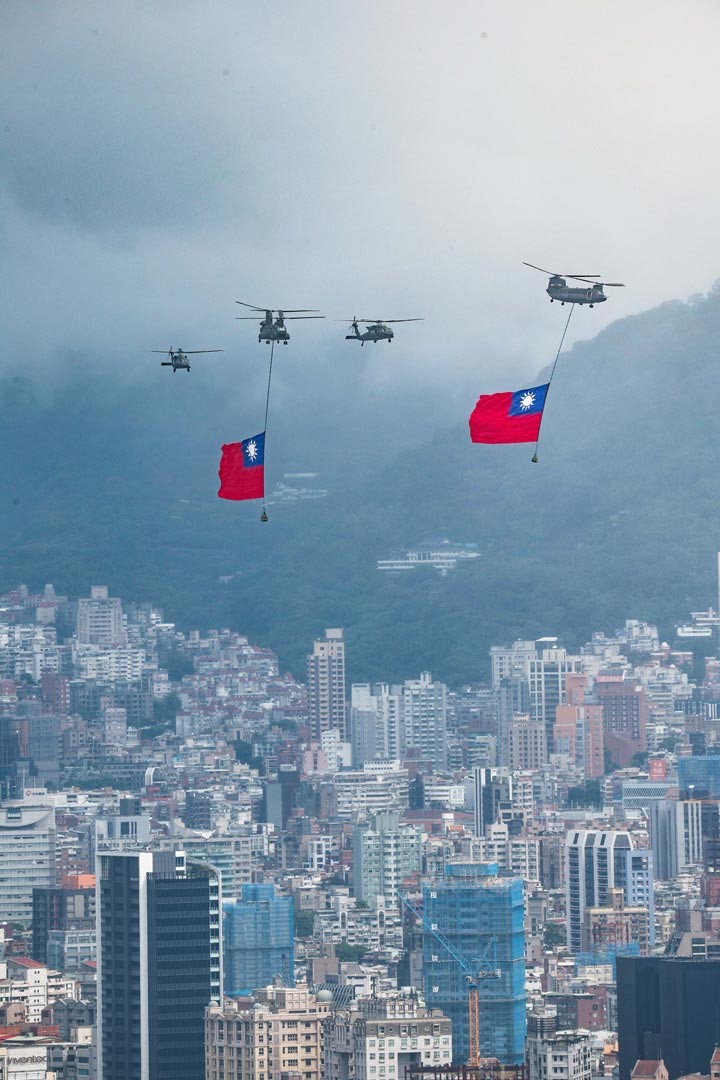 陸航CH-47SD運輸直升機吊掛巨幅國旗，伴隨2架UH-60M通用直升機，在國歌聲中緩緩通過總統府前。