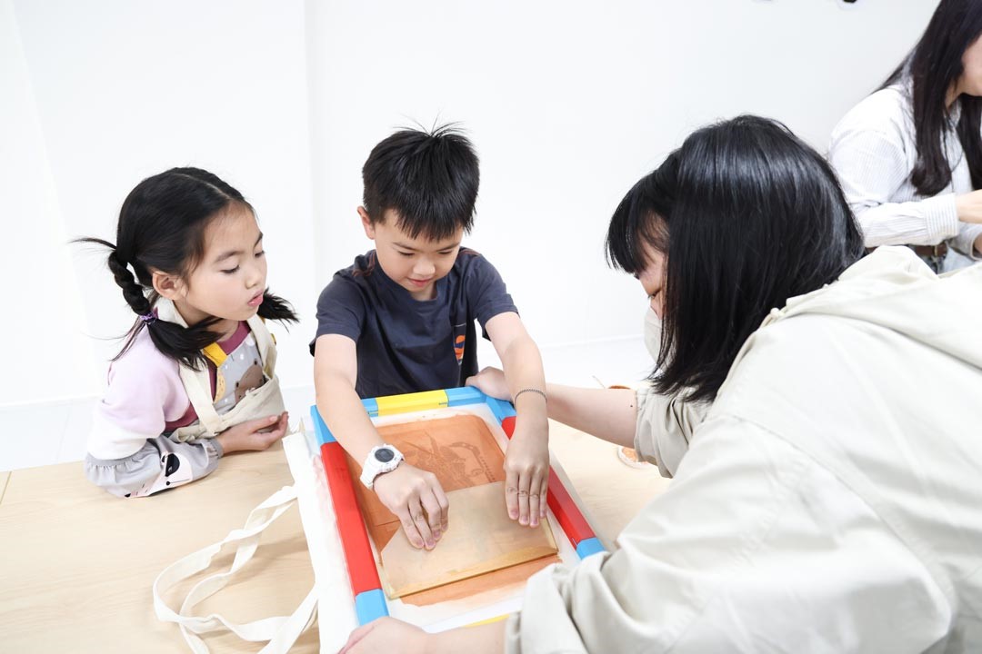 孩童專注體驗傳統絹印的樂趣。