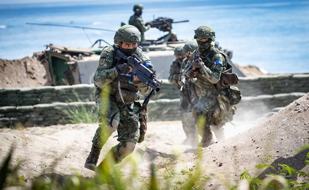 烈日下，官兵在沙地上勤跑戰術。